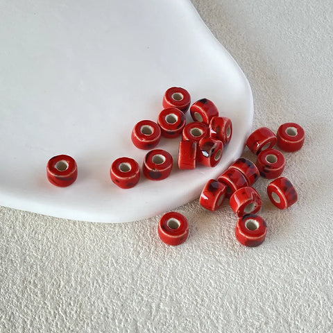 BD00018-02-red-speckle-coin-ceramic-beads-6x9mm