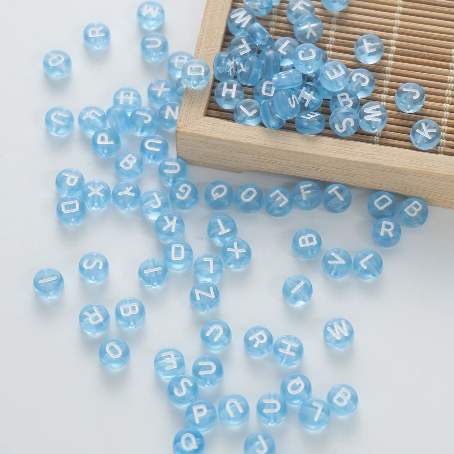 BW-00064-BD-05-white-letter-light-blue-transparent-coin-alphabet-beads-mix-4×7mm