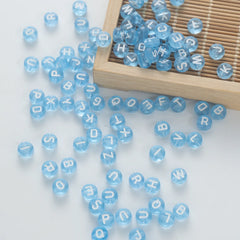BW-00064-BD-05-white-letter-light-blue-transparent-coin-alphabet-beads-mix-4×7mm